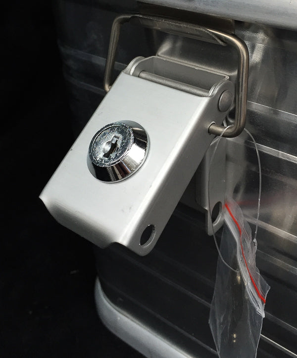 Nærbilde av låsbar hurtiglås med nøkkel på aluminiumsboksen