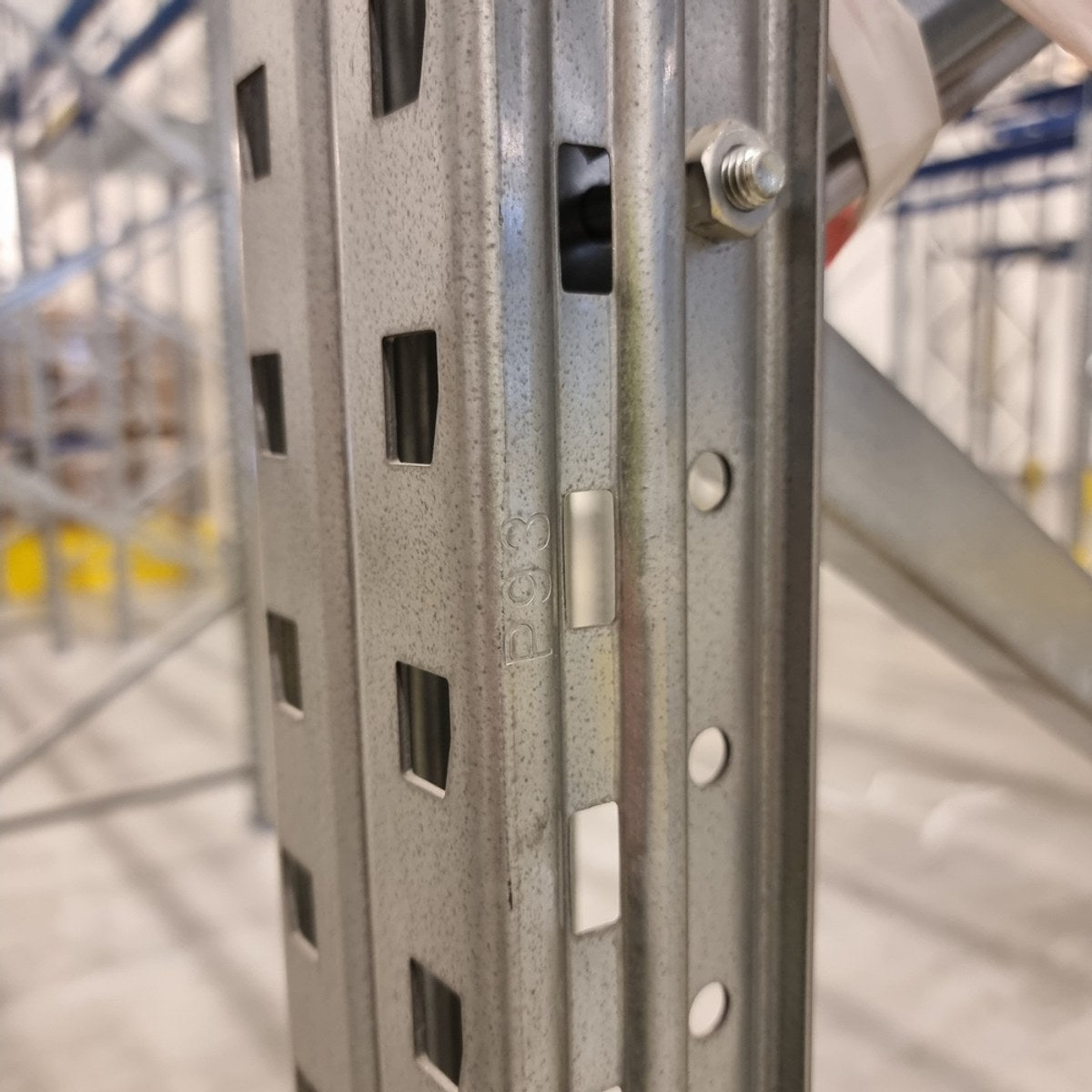 Nærbilde av systembetegnelse preget inn i stolpeprofilen på en brukt pallereolstige.